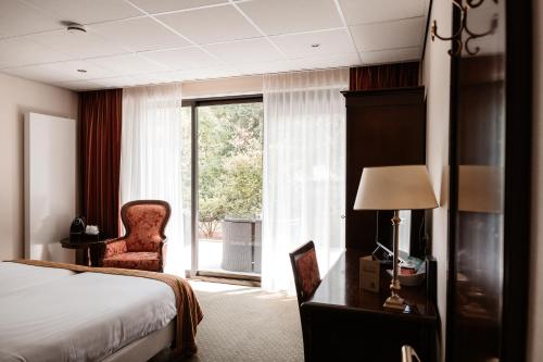 卢特伦德伦特斯波尔酒店的酒店的客房 - 带一张床、椅子和窗户