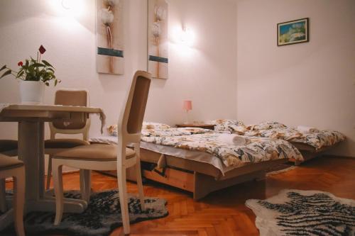 萨拉热窝Nina Apartment的一间卧室配有一张床、一把椅子和一张桌子