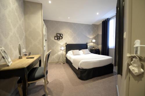 尼奥尔法国酒店的酒店客房配有一张床、一张书桌和一张书桌。