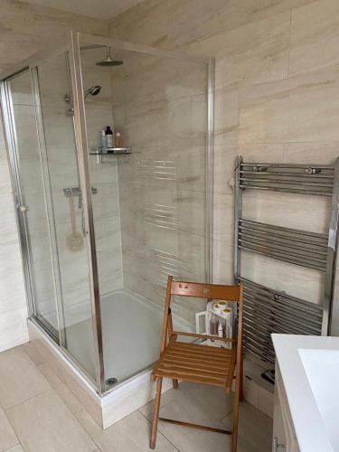 克罗伊登Cozy home的带淋浴的浴室和木椅