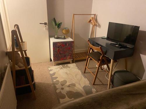 克罗伊登Cozy home的客房设有一张桌子、一台电脑和一把椅子