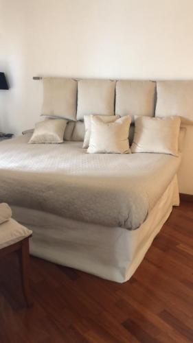 韦尔巴尼亚Little Suite Near Lake的一张铺有木地板的带白色枕头的大床
