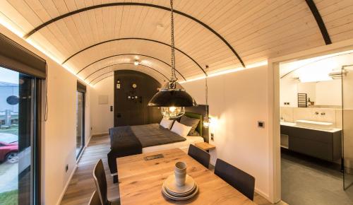 斯塔德特罗恩LokoMotel-Waggon, Luxus Appartment im Eisenbahnwaggon的一间客房内配有床和桌子的房间