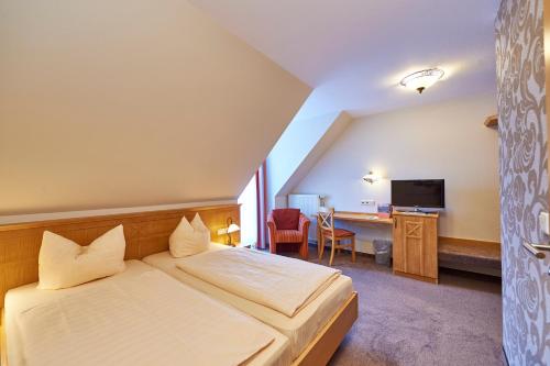弗隆海姆克劳斯特斯特鲁贝尔酒店的配有一张床和一张书桌的酒店客房