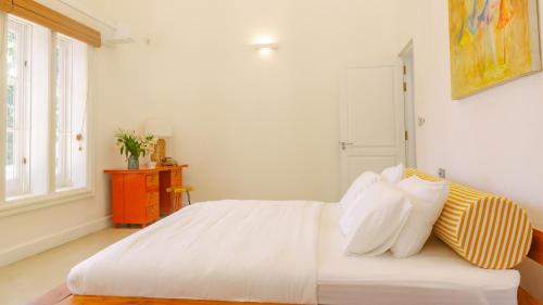康提Fairy Cottage Kandy的一间卧室配有带白色床单和枕头的床。