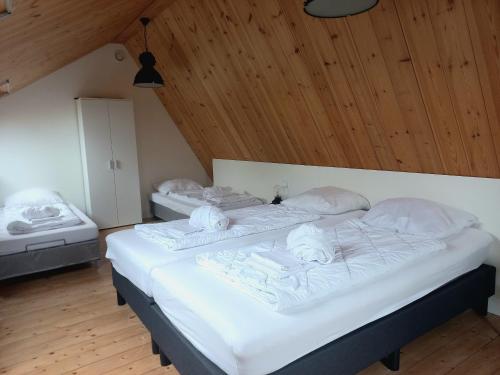 阿布考德Ruim appartement in prachtige fiets-wandelomgeving的配有木天花板的客房设有两张床。