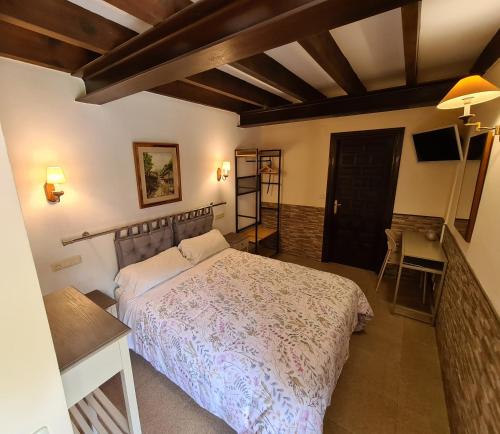 里瓦德塞利亚Amaicha casona的一间卧室配有一张床、一张桌子和一台电视