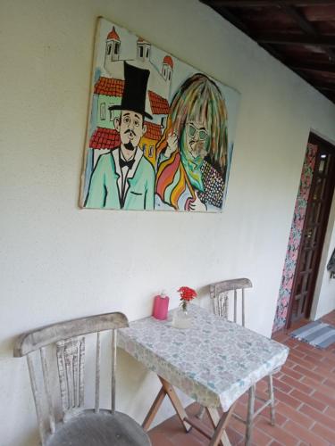 嘎林海斯港Exclusive Guest House的一张桌子、两把椅子和墙上的一幅画