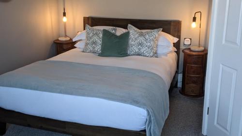 韦茅斯Oaklands Guest House的一间卧室配有一张带枕头的大床