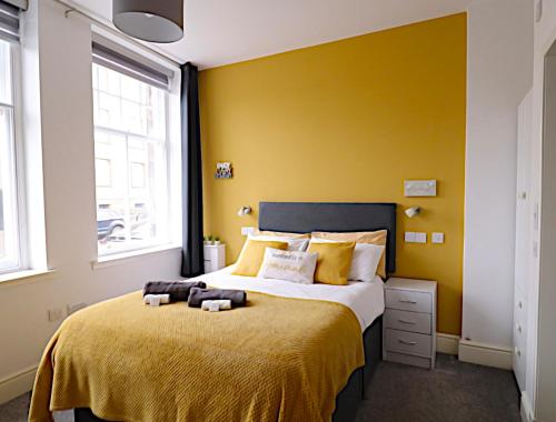 柯科迪Double Ensuite Bedroom near Edinburgh的一间卧室设有一张黄色墙壁的大床