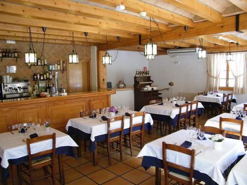 利亚沃尔西HOTEL LAMOGA的用餐室配有带白色桌布的桌子