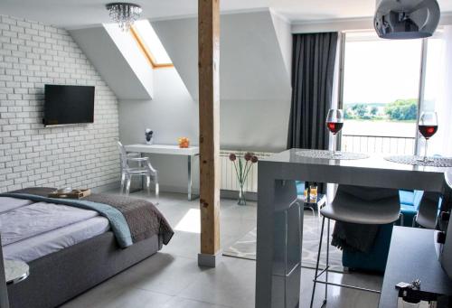 厄尔科Apartamenty Na Skarpie的一间卧室配有一张床和一张带葡萄酒杯的桌子