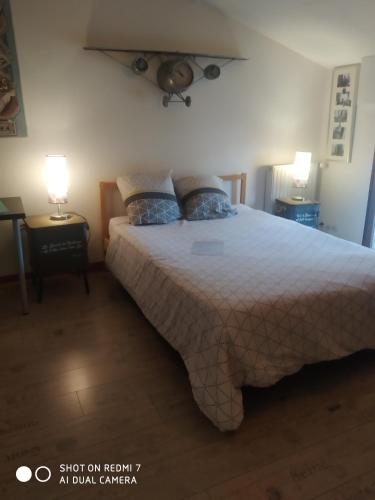 布格奈斯Aéroport chambre ,au calme的一间卧室配有一张大床和两个蓝色枕头