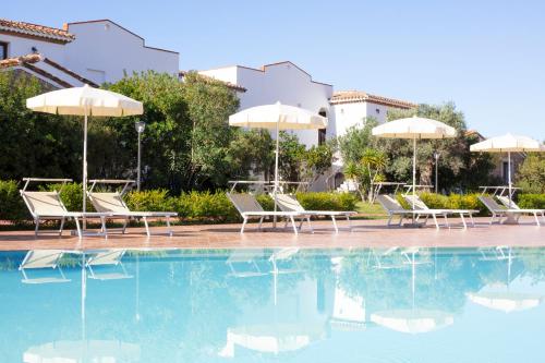 圣玛丽亚纳瓦雷Marina Torre Navarrese Resort的度假村内带椅子和遮阳伞的游泳池