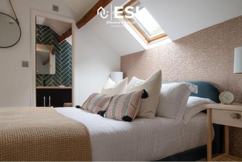 ShelveLuxurious 2 Bedroom Countryside Hot Tub Retreat in Stiperstones的卧室配有带白色枕头的床和窗户。