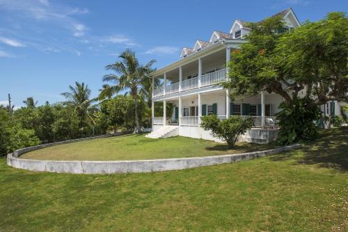 总督港Buccaneer Hill Main House home的一座大型白色房子,设有大院子