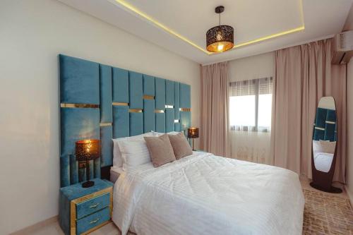 马拉喀什Cozy 2-bedroom apartment in Gueliz, Marrakech的一间卧室配有一张大床和蓝色床头板