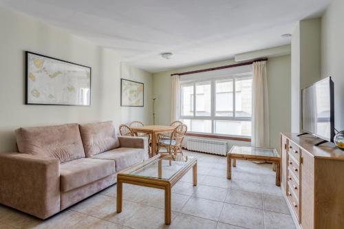 桑亨霍Apartamentos Granxola的客厅配有沙发和桌子