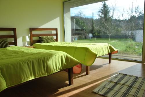 布拉加卡斯坦内罗度假屋的一间卧室设有两张床和大窗户