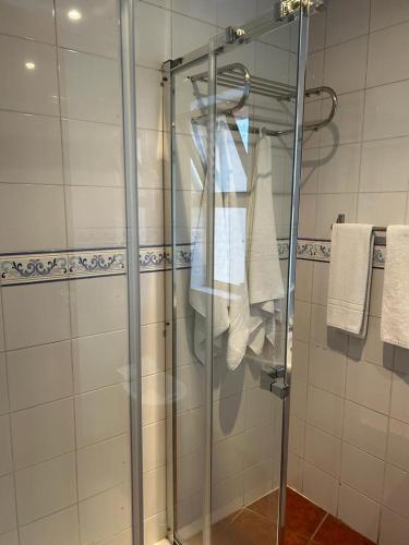 卡帕里卡海岸Copacabana Residencial的浴室设有玻璃淋浴间,备有毛巾