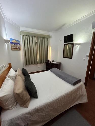 卡帕里卡海岸Copacabana Residencial的卧室配有带枕头的大型白色床