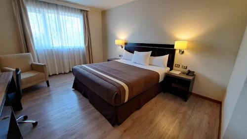 库里科库里科阿尔马格罗迪亚哥酒店的配有一张床和一把椅子的酒店客房
