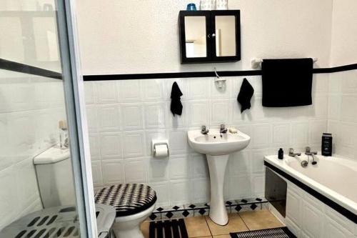 乌旺戈海滩Seaview Beachfront Holiday Apartment - 164 Laguna La Crete的白色的浴室设有水槽和卫生间。