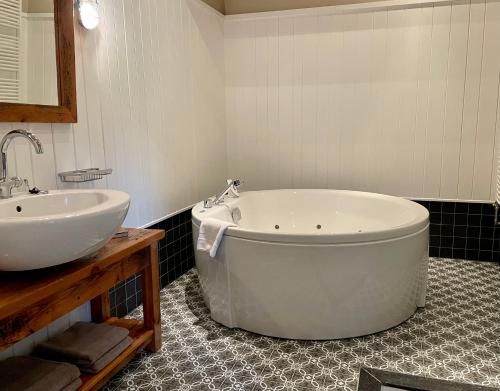 RottevalleTeades Plak bij De Herberg van Smallingerland的一间带大浴缸和水槽的浴室
