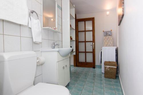 圣尼古拉奥斯Bostani Seaside House Mani的白色的浴室设有卫生间和水槽。
