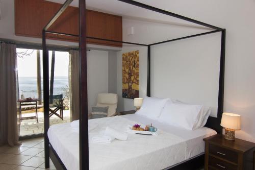 圣尼古拉奥斯Bostani Seaside House Mani的一间卧室设有一张床,享有海景