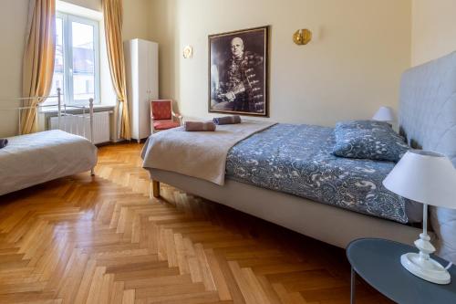 华沙Apartament luster i obrazów的一间卧室配有一张床和一张带台灯的桌子