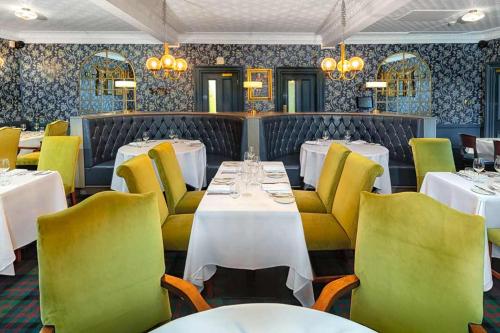 金洛赫兰诺赫Loch Rannoch Hotel and Estate的餐厅设有白色的桌子和黄色的椅子