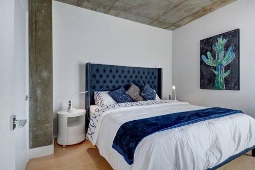 魁北克市Les Immeubles Charlevoix - 760-505的白色卧室配有一张带蓝色枕头的大床