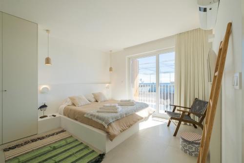圣罗克Casa dos Pedros (Beach House)的一间白色卧室,配有床和阳台