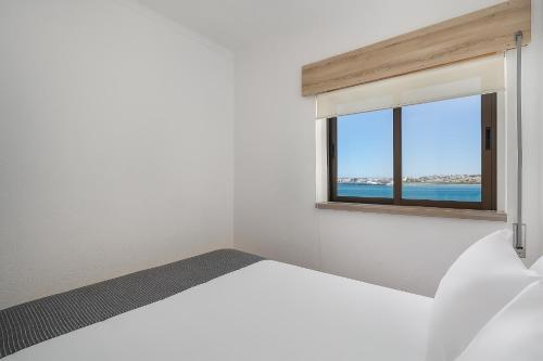 波尔蒂芒Vista Rio - apartamento的卧室配有白色的床和窗户。