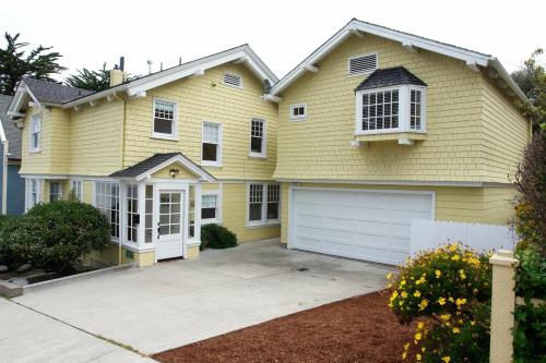 太平洋丛林3118 Yellow House Main home的黄色房子,设有白色车库