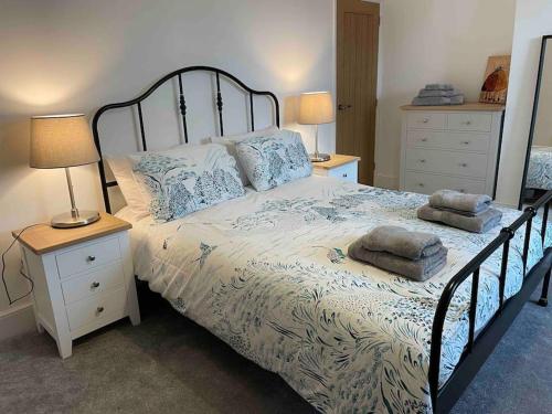 埃文河畔斯特拉特福May cottage in Stratford Upon Avon的一间卧室配有一张带2个床头柜的大床