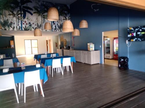 普拉亚多斯卡内罗斯Eco Resort Praia dos Carneiros - Flat 116CM, apartamento completo ao lado da igrejinha的用餐室配有蓝色桌子和白色椅子