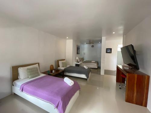 长滩岛Everrich Boutique Resort Boracay的一间卧室配有一张床,并在一间客房内配有电视。
