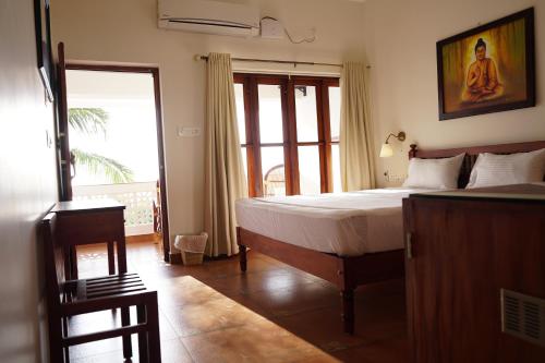 可瓦兰Buddha Beach Hotel的一间卧室设有一张床和一个大窗户