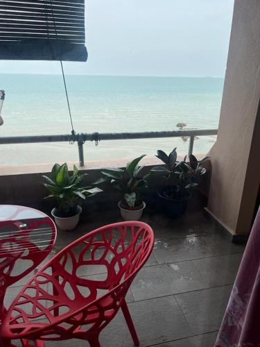 波德申PD VIP SEAVIEW w Wifi n Smart TV的海滩景阳台的红色椅子