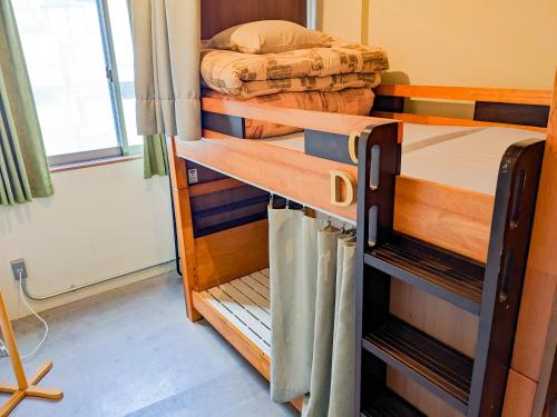 大阪Hostel JIN - Weekly Appartment in Osaka的带窗户的客房内的两张双层床