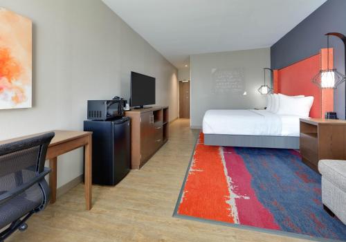 莱克韦La Quinta Inn & Suites by Wyndham Lakeway的一间酒店客房,配有一张床和一台电视