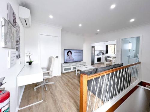 IngleburnBrand new 2 Bedrooms Apartment in Ingleburn的白色的客厅配有桌子和电视