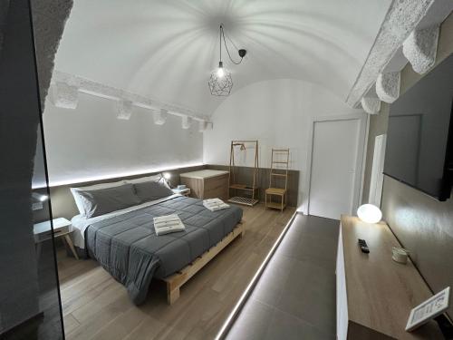 布林迪西Archome Luxury Apartment的一间卧室配有一张床和一台电视。