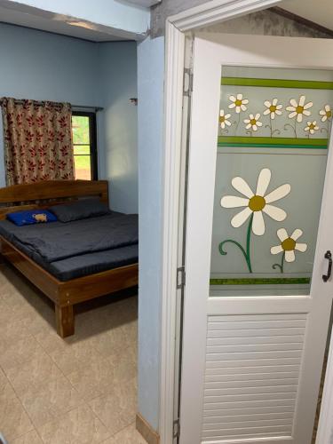 罗勇NADOHN2 San Fan Homstay的一间卧室设有一张床和一个带花卉壁画的窗户。