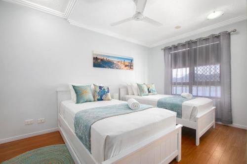 凯恩斯604 Chic City Apartment with Water Views的一间卧室设有两张床和窗户。