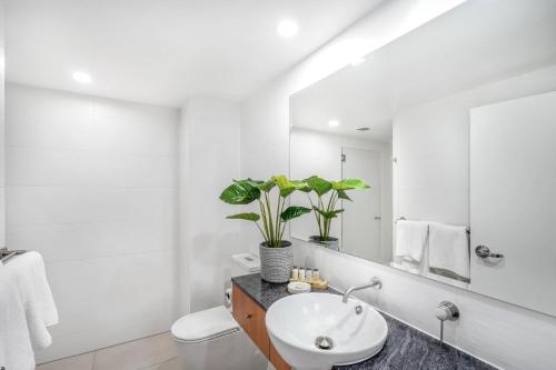 棕榈湾Belle Escapes presents 14 Alamanda Resort Where Pure Luxury meets the Coral Sea的白色的浴室设有水槽和镜子