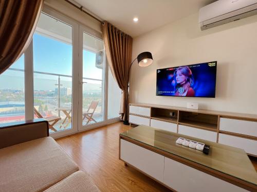 下龙湾Sky Halong Apartment的客厅的墙上配有平面电视。