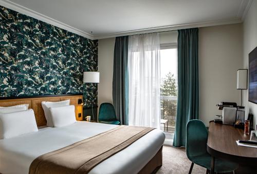 布洛涅-比扬古巴黎布洛涅酒店的配有一张床、一张书桌和一扇窗户的酒店客房